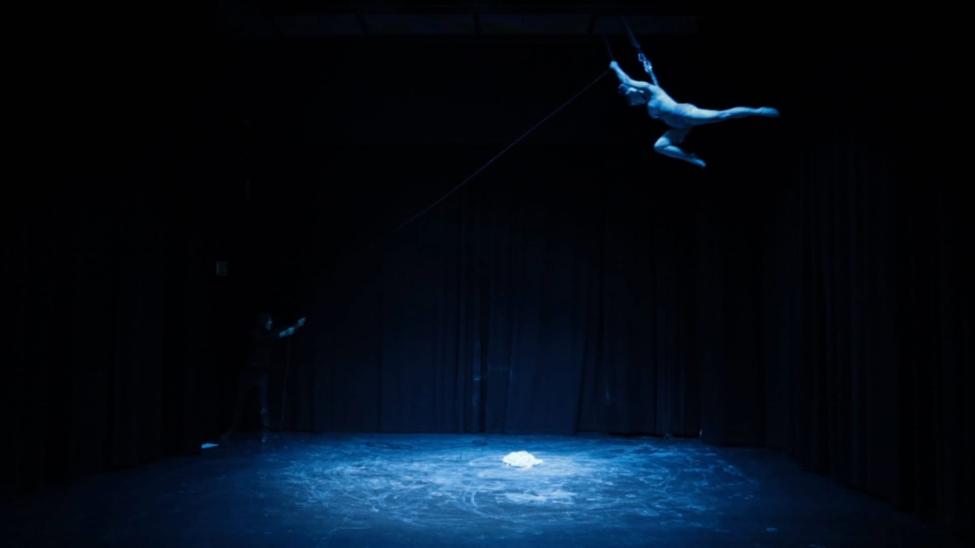 A suspended performer flying above the stage in Horse Heart